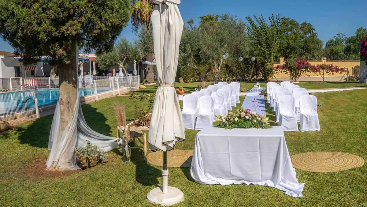 Jardín de Finca La Calza con la piscina, los olivos y las sillas preparadas