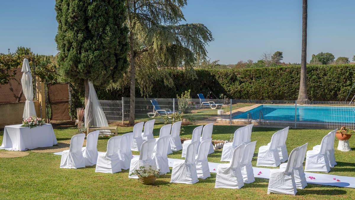 Sillas blancas junto a la piscina de Finca La Calza