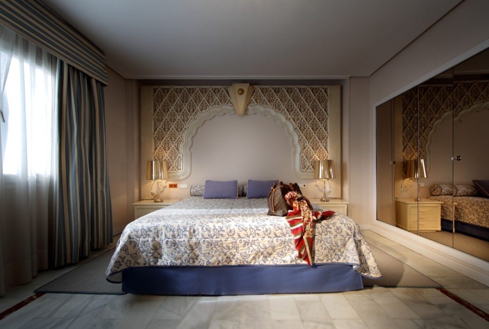 Dormitorio con cabecero de inspiración andalusí en el Hotel Abades Benacazón